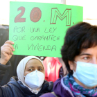 Una mujer levanta una pancarta a la manifestación del movimiento por la vivienda.