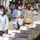 Una noia mirant llibres en una parada de la Rambla Nova de Tarragona durant la Diada de Sant Jordi.