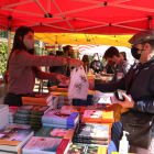 Persones comprant llibres en una de les parades del parc Sant Jordi de Reus.