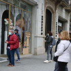 Vianants curiosos miren les destrosses causades a les botigues del Passeig de Gràcia.