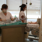 Imatge de dues infermeres atenent un nen fent tractament a l'Hospital de Dia de Vall d'Hebron
