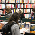 Pla conjunt de diverses persones mirant llibres en una llibreria.