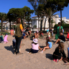 Pla general d'un grup d'escolars plantant plantes al dunar del parc de Voramar d'Altafulla.