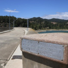 Una placa donde se lee que las aguas son propiedad de la comunidad de regantes, en el pantano de Riudecanyes.