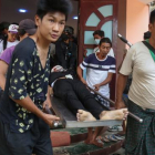 El cuerpo de un joven de 18 años que recibió un disparo en la cabeza es transportado durante los disturbios en Birmania (Myanmar).