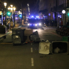 Una pequeña barricada con contenedores en la Rambla de Barcelona, con unas furgonetas de los Mossos en segundo plano.