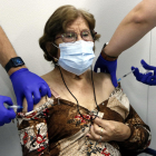 Imatge de com posen a una senyora major de 70 anys de forma simultània la vacuna de la grip i la tercera dosi de la de la covid-19.