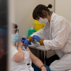 Una professional de l'Hospital Clínic de Barcelona rep la tercera dosi de la vacuna contra la covid-19.