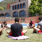 Uns menors fent estiraments als jardins d'un centre terapèutic per a adolescents, del grup Amalgama7, ubicat a l'Alt Camp.