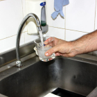 Imagen de archivo de una mano llenando un vaso de agua al grifo.