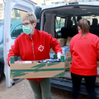 Dos miembros de la reo Roja de Tarragona descargando alimentos perpujar-los en el piso de una persona mayor en el barrio dde Sant Salvador.