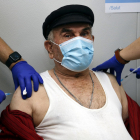 Un hombre es vacunado simultáneamente de la gripe y de la tercera dosis de la covid-19.