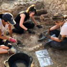 Unas arqueólogas excavando una chimenea de la estancia; en el fondo, la estructura de la cocina griega del siglo VI a.C.