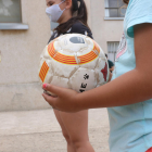 Plano detalle de una pelota a manos de una niña participando en el centro de verano de la Fundació Pere Tarrés en Torredembarra.