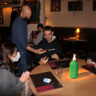 Un restaurador comprovant el passaport covid a un bar de Gràcia.