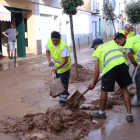 Un grup de voluntaris de l'Ametlla de Mar treballant en les tasques de neteja d'un dels carrers principals de les Cases d'Alcanar.