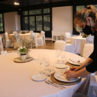 Una camarera parando una mesa en la sala de un restaurante. Imagen de archivo.