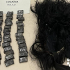 Varios envoltorios de cocaína al lado de una peluca.