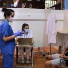 Una enfermera dando explicaciones a un joven que acaba de recibir la vacuna contra la covid-19 en el pabellón Onze de Setembre de Lleida.