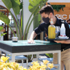 Un cambrer d'un restaurant de Sitges netejant la taula entre serveis d'aperitius.