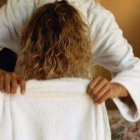 Imagen de una mujer secándose el pelo.