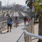 Personas cruzando la pasarela que facilita el acceso desde la Bajada del Toro hasta la playa.