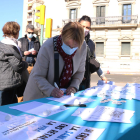 Una mujer firmando las peticiones hechas por los miembros del grupo.