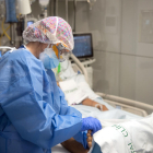 Una enfermera del Hospital Clínic hace un masaje en el pie a un paciente ingresado en el área de Cuidados intensivos (AVI, o UCI), durante la quinta oleada de la pandemia de la covid-19 en Cataluña.