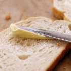 Imagen de archivo de margarina extendida sobre una rebanada de pan.