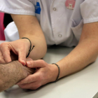 Las manos de una enfermera tomando el pulso a un paciente, en el CAP Vinyets de Sant Boi de Llobregat