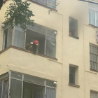 Un bomber treu el cap per una de les finestres del pis.