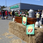 Un primer pla del taüt i garrafes de palla amb la mobilització dels pagesos de fons davant el Mercadona de Vic el 27 de juliol del 2021.