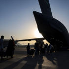 Un grup d'afganesos s'acosta a un avió de l'exèrcit dels Estats Units, a l'aeroport de Kabul, per ser evacuats.
