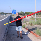 Plano abierto del activista por la liberación de la AP-7, Llorenç Navarro, con una de las barreras al antiguo peaje de L'Aldea.