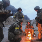 Soldats ucraïnesos s'escalfen en una foguera a prop de Kíev.