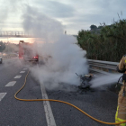 Imagen de Bombers apagando el vehículo incendiado.