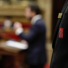 Escudo del Parlament en la solapa de la chaqueta de un trabajador de la cámara.