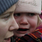 Un menor plora en braços de la seva mare a la frontera d'Ucraïna amb Rumania.
