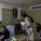 Una mare agafa en braços al seu fill nounat al soterrani d'un hospital de maternitat, utilitzat ara com a refugi antiaeri a Kíev.