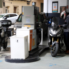 El conductor d'una moto posant combustible a la gasolinera.