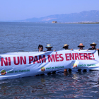 Membres d'Unió de pagesos subjectant una pancarta a la badia dels Alfacs.