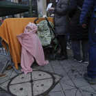 Ucranianos que huyeron de su país en medio de la invasión rusa en curso hacen cola frente a una oficina de inmigración en Bruselas.