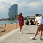 Dos turistes fent-se una foto amb l'hotel Vela de fons.