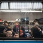 Estación de ferrocarriles de Lviv con civiles saliendo en tren.