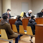 Los dos ciudadanos acusados sentados en frente y el agente de la Guardia Urbana detrás, en la Audiencia de Lleida.