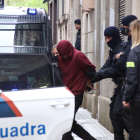 El detenido sale escoltado por los mossos|mozos.