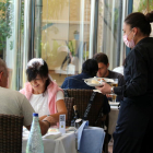 Una camarera sirviendo platos a dos clientes en el restaurante del Hotel Miami de Sant Carles de la Rápita.