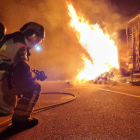 Un bomber extingint el foc del camió.