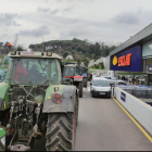 Una cua de tractors entrant a l'aparcament d'un supermercat de Girona.