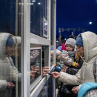 Una mujer entrega el pasaporte en la frontera entre Ucrania y Eslovaquia.